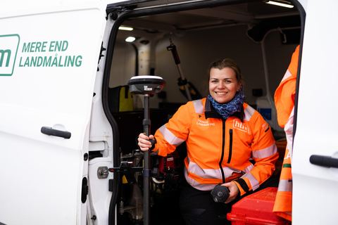 HLM-landmåler med GNSS-rover ved den åbne sidedør på en af HLM's varevogne