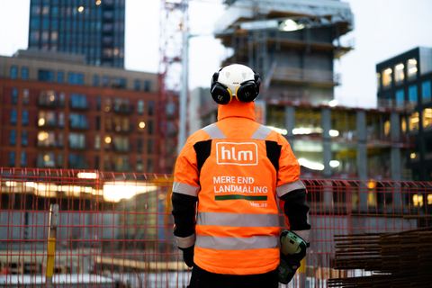 HLM-medarbejder ser ud over et højhusbyggeri i skumringen - Vi sætter målet